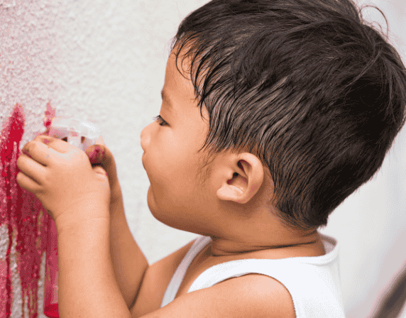 Kid scribbling on wall
